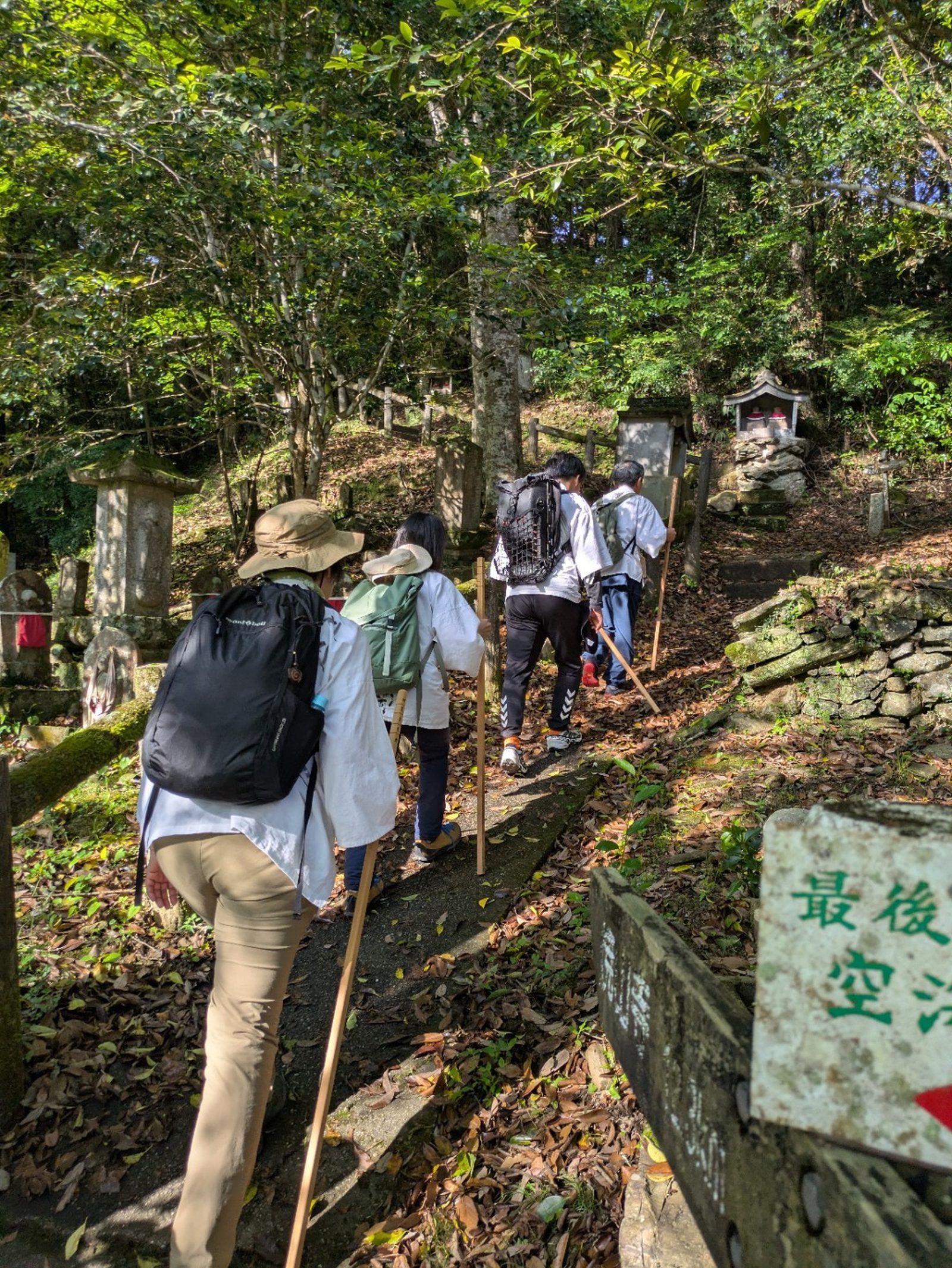 石灯籠の並ぶ参道を歩くお遍路一行