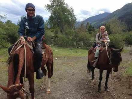 赤ちゃんをおんぶして馬で旅する家族